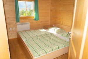 モジリェにあるhouse on the top of the hillのログキャビン内のベッド1台が備わる小さな客室です。