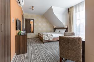 ジビジノにあるPokoje Palickiのベッドと椅子付きのホテルルーム