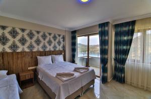 a bedroom with a bed and a large window at Amasra Sunrise Otel in Bartın