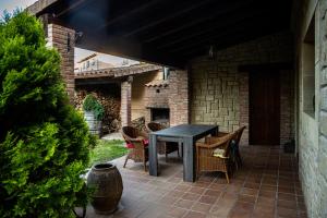 um pátio com uma mesa e cadeiras e um edifício de tijolos em Casa Almoravid em Daroca de Rioja