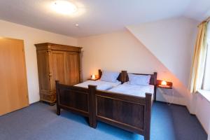 Schlafzimmer mit einem Bett und einem Holzschrank in der Unterkunft Rhododendronhof in Behringen