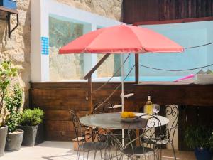 einen Tisch mit einem roten Regenschirm auf einer Terrasse in der Unterkunft Boreal Porto Gaia - Patio & Pool in Vila Nova de Gaia
