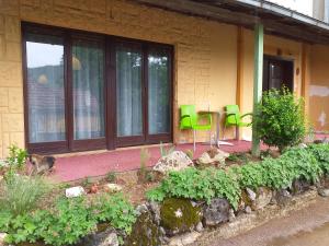 una casa con sillas verdes y una mesa en un jardín en BANJSKI PUT, en Niš