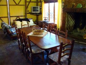 ein Esszimmer mit einem Tisch, Stühlen und einem Kamin in der Unterkunft Estancia Don Jose- GuenGuel in Río Mayo