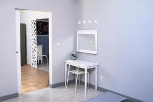 a room with a white table and a mirror at Apartament pod Morwą in Lubniewice