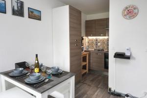 a kitchen with a table with a bottle of wine at Ron's Apartment in Colmar