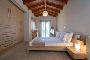 Un dormitorio con una cama grande con techo de madera. en Lagonisi luxurious residence Ruby's Pool Villa, en Lagonisi