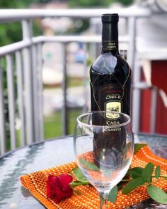 uma garrafa de vinho e um copo sobre uma mesa em Apartmani Tamara em Vrnjačka Banja