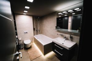 a bathroom with a tub and a sink and a toilet at AH Luxury Baštová 10 in Košice +36 photos