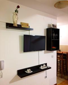 uma sala de estar com uma televisão na parede em Apartmani Tamara em Vrnjačka Banja