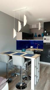 a kitchen with a blue and white counter and stools at GARDENIA BLUE APART Dziwnów z widokiem na morze in Dziwnów +40 photos