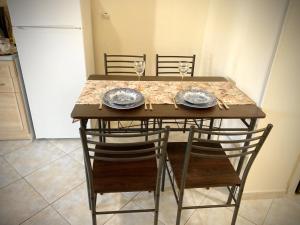a table with two chairs and two plates and wine glasses at Kallithea studio in Kallithea Halkidikis