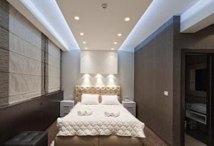 una camera da letto con un letto grande con lenzuola bianche di Centrum Sobe Rooms Čačak a Čačak