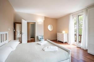 a white bedroom with a bed and a window at Casa Gelsomina in Gardone Riviera