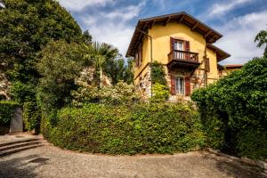 a yellow house with a fence and stairs in front of it at Casa Gelsomina in Gardone Riviera