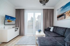 a living room with a couch and a large window at Apartamenty Relax in Władysławowo