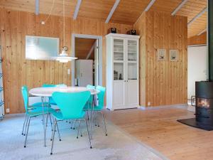 a dining room with a table and blue chairs at 6 person holiday home in Gedser in Gedser