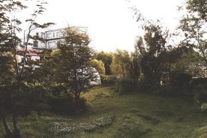 un edificio in lontananza con alberi e un prato di Hosteria Foike a Ushuaia