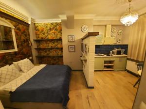 a bedroom with a bed and a kitchen at Studios on Grigore Vieru in Chişinău