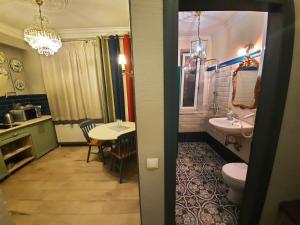 a bathroom with a sink and a toilet and a table at Studios on Grigore Vieru in Chişinău +16 photos
