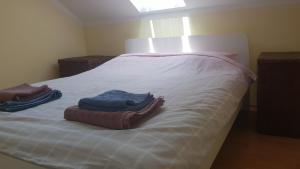 a bedroom with two towels on a white bed at Apartman Vid in Soko Banja