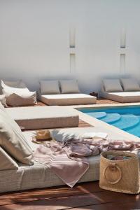 una fila di materassi seduti accanto alla piscina di Tierra del Mar Hotel - Adults Only a Isola Holbox