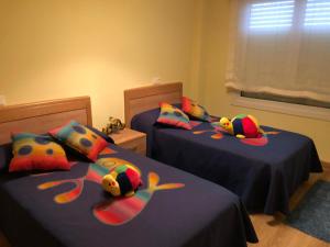 two beds with stuffed fish pillows in a bedroom at Apartamento Playa San Pedro in Barreiros
