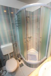La salle de bains est pourvue d'une douche, de toilettes et d'un lavabo. dans l'établissement Apartments villa Mira, à Kaštela
