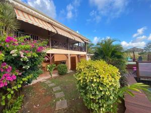 a house with flowers in front of it at La Villa FLau Studio Azur in Sainte-Luce