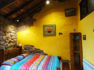 a bedroom with a bed in a yellow wall at Apartamento en Plena Naturaleza in La Cavada