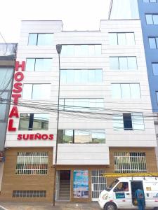 Hostal Sueños في ليما: سيارة فان بيضاء متوقفة أمام مبنى