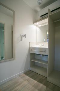 Bénesse-Maremneにあるモーテル デ ランデスのバスルーム(洗面台、鏡付)
