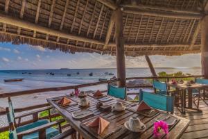 een tafel op het strand met uitzicht op de oceaan bij SeVi Boutique Hotel in Matemwe