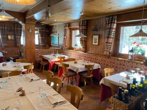 a restaurant with tables and chairs in a room at Hotel Miravalle in Courmayeur