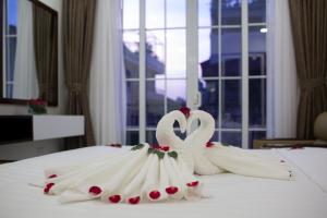 Dos cisnes blancos en un vestido de novia en una cama en Dream Central Hotel, en Hanói