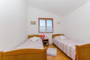 two beds in a room with white walls at Apartments Bosiljka - by the sea in Sevid