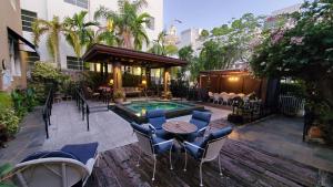 een patio met een tafel en stoelen en een zwembad bij Cadet Hotel in Miami Beach