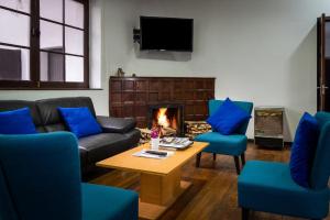 sala de estar con sofá, sillas y chimenea en El Museo Hotel Boutique, en La Paz