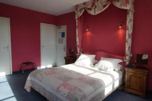 オンフルールにあるホテル ラ ディリジョンスの赤い壁のベッドルーム1室(大型ベッド1台付)