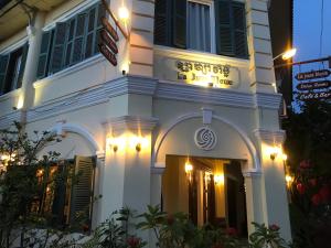 a white building with lights on the side of it at Hotel La Java Bleue in Kampot