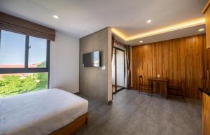 a bedroom with a bed and a desk and a television at Coast House Boutique Hotel in Nha Trang