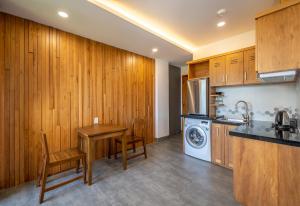 a kitchen with a table and a washing machine at Coast House Boutique Hotel in Nha Trang