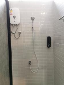 a shower in a bathroom with a phone on the wall at The 8 hostel Buriram in Ban Bu Lamduan