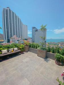 un patio con bancos y vistas a la ciudad en Coast House Boutique Hotel, en Nha Trang