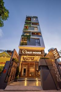 um edifício alto com uma placa de casa costeira em Coast House Boutique Hotel em Nha Trang