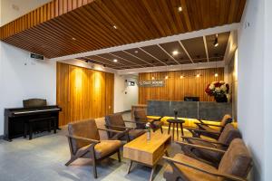a lobby with a piano and chairs and a table at Coast House Boutique Hotel in Nha Trang