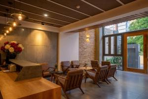 a dining room with chairs and a table and flowers at Coast House Boutique Hotel in Nha Trang