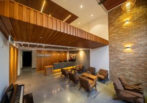 a lobby of a restaurant with chairs and tables at Coast House Boutique Hotel in Nha Trang