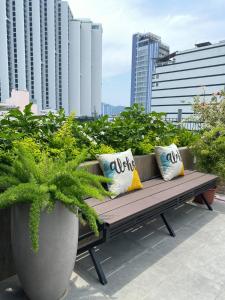 a wooden bench with pillows on a balcony with plants at Coast House Boutique Hotel in Nha Trang