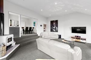 a living room with a white couch and a tv at Queenstown Hill Haven in Queenstown